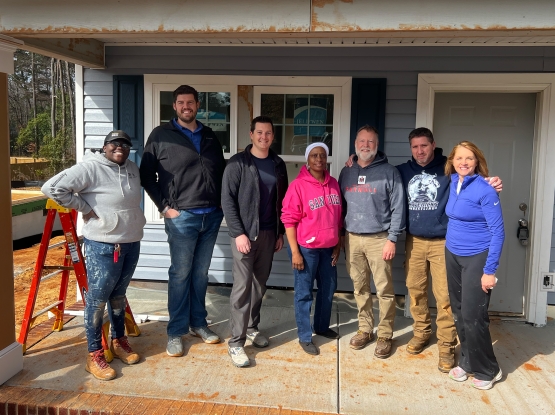 group of people on a porch of a house under construction